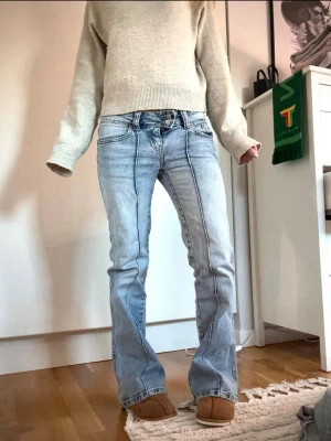 Ljusblå bootcut jeans  - Säljer ett par ljusblå bootcut jeans med markerade kontrastsömmar framtill. Jeansen har låg midja och är tillverkade i denim med lätt tvättad look. Storlek xs short🥰🥰 