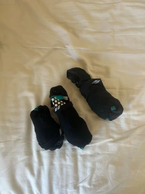 Svarta strumpor med prickar - Säljer ett gäng svarta strumpor med vita och gröna prickar samt små detaljer i turkos. Strumporna är låga och passar perfekt till sneakers. Materialet är mjukt och stretchigt, troligen bomull och polyester. Perfekt för dig som vill ha lite färg på fötterna.