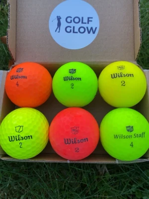 Wilson Staff färgade 6-pack - Säljer ett 6-pack golfbollar från Wilson i neonfärger: orange och gul. Perfekta för att synas på banan! Bollarna har klassisk dimple-yta och är märkta med olika nummer. Kommer i en låda med GOLF GLOW-logga.