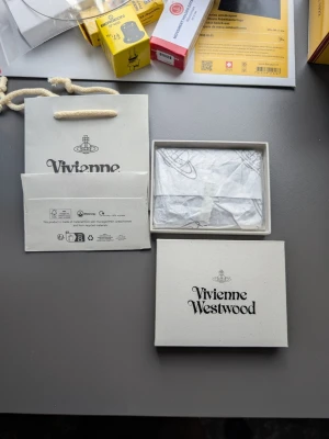 Svart korthållare Vivienne Westwood - Snyggt svart kortfodral från Vivienne Westwood i croc-embossat läder. Fodralet har flera kortfack och pryds av det ikoniska silvriga orb-emblemet framtill. Kommer med original ask och påse, perfekt för dig som vill ha något stilrent och trendigt.