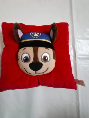 Supersnygg Chase Paw Patrol kudde i jättefint skick - Ny röd kudde från barnserien Paw patrol med hunden Chase på. Oanvänd. Köpt och glömd i garderoben.