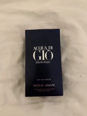 Acqua di Giò Profondo Eau de Parfum - Acqua di Giò Profondo Eau de Parfum från Giorgio Armani. Parfymen kommer i en elegant mörkblå rektangulär kartong med silverfärgad text. Perfekt för dig som gillar fräscha och marina dofter. Materialet är kartong.