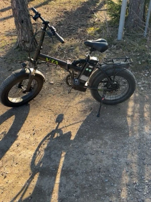 Svart elcykel med tjocka däck volt vta  - Säljer en svart elcykel med breda däck och robust ram. Cykeln har en bakre pakethållare, hopfällbar design och batteri monterat på ramen. Perfekt för terräng och stadskörning, med bekväm sadel och tydliga kontroller på styret.