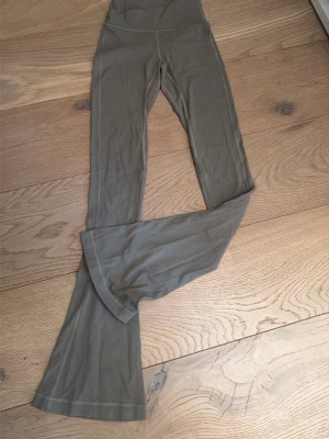 Olivgröna flare leggings från Lululemon - Säljer ett par olivgröna leggings från Lululemon med hög midja och utsvängda ben. Materialet är stretchigt och mjukt, vilket gör dem riktigt bekväma. Dom ser mindre  ut en dom är 💞💞priset kan diskuteras 