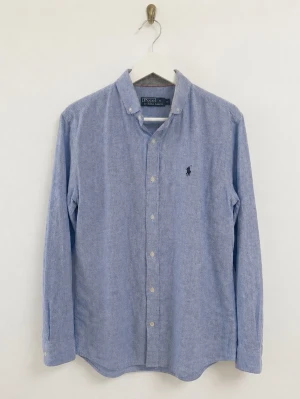 Ralph lauren skjorta - Ralph lauren skjorta i gott skick! Känns som linne i materialet och är utmärkt nu inför sommarn. Färgen är i en ljus blå färg. Storlek M sitter som M.