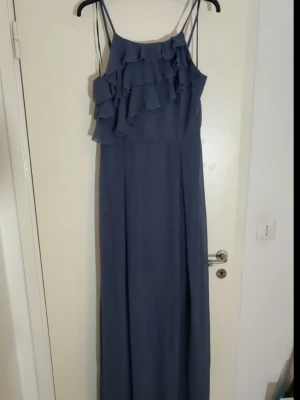 Grå/blå Snygg Festklänning i Nyskick - Snygg festklänning från Vila i strlk 40, i Nyskick med prislapp kvar . Klänningen är mycket finare i verkligheten. Kan skicka fler bilder på klänningen om det önskas. 