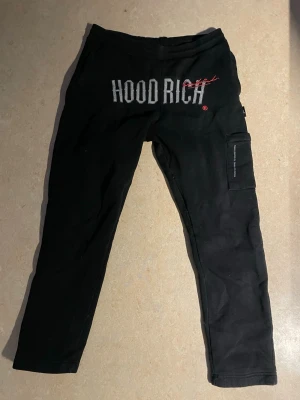 Svarta mjukisbyxor från Hoodrich - Svarta mjukisbyxor från Hoodrich med tryckt logga framtill och en praktisk ficka på benet. Pris kan diskuteras