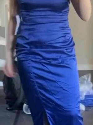 Blå långklänning i satin - Snygg blå långklänning i glansigt satinmaterial med figurnära passform och slits framtill. Klänningen är ärmlös och har en stilren, enkel design som ger en elegant look. Mörkblå 