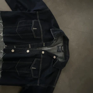 Mörkblå croppad jeansjacka - Mörkblå croppad jeansjacka, fickor går att öppna och stänga, samma gäller jackan i sif