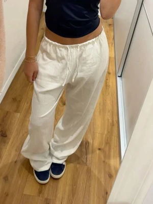 Vita linnebyxor - Säljer ett par vita lågmidgade linnebyxor från HM. Byxorna har raka ben och är tillverkade i 100% linne. Perfekta för en chill och stilren look.