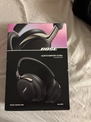 Bose QuietComfort Ultra hörlurar - Snygga svarta Bose QuietComfort Ultra over-ear hörlurar med brusreducering. Andra generationen med modern design, mjuka öronkuddar och metalliska detaljer. Perfekta för musik, gaming eller poddar när du vill ha riktigt bra ljud och komfort.