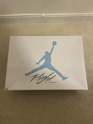 Nike Air Jordan 4 University Blue - Säljer ett par Nike Air Jordan 4 University Blue sneakers i ljusblå mocka med grå och svarta detaljer. Skorna har klassisk meshpanel, snörning och specklad grå hälkappa med Jumpman-logga. Riktigt snygga och eftertraktade sneakers för dig som vill sticka ut. Passar mindre än 44.