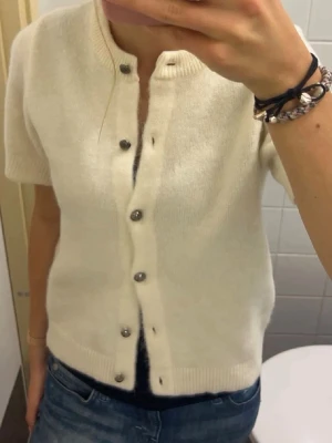 Gina kofta - Kortärmad stickad tröja med knappar från Gina! Kommer tyvärr inte till användning. Har haft den cirka 3 gånger så den är i fint skick 💕 nypris runt 400kr. Passar XS-S