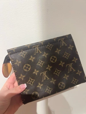 Brun handväska - Snygg brun plånbok, Tillverkad i tåligt läder med dragkedja och guldfärgade detaljer. Perfekt för dig som gillar lyxiga accessoarer och vill ha något tidlöst.