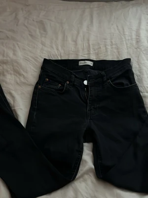Svarta bootcut jeans - Säljer ett par svarta bootcut jeans från Gina tricot med klassisk femficksdesign och dragkedjegylf. Jeansen har en smal passform och är tillverkade i stretchigt material för extra komfort. Perfekta till en avslappnad Stockholms eller clean girl look.