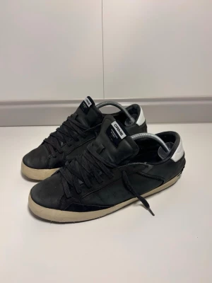 Crime London Sneakers - Ett par Crime London Sneakers i helt okej skick, 6/10. Ett litet hål i sulan och sömmen har lossnat lite som på bilderna, överlag helt ok skick. Storlek 43, pris 349. Fraktar samma dag!