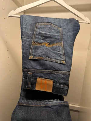 Nudie Jeans ”Grim Tim” - Säljer ett par riktigt feta Nudie Jeans i modellen ”Grim Tim”, den har en riktigt fräsch tvätt/blekning runt om hela byxan, perfekt hela året om. Storleken är W34-L32! Bild på finns sista 2 bilderna. Skicket är 8-10 och köpt för cirka 1599 kr på deras egna butik. Finns inga hål eller synliga tecken på slitage! Kom PM för mer information/frågor! KAN GÅ NER I PRIS VID SNABB AFFÄR! 🤝🏻