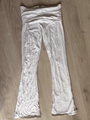 Vita mjukisbyxor med utsvängda ben - Säljer ett par vita mjukisbyxor från Gina Tricot med bred linning och utsvängda ben. Byxorna är tillverkade i ett mjukt och stretchigt material som känns skönt mot huden. Perfekta för en avslappnad och chill stil.
