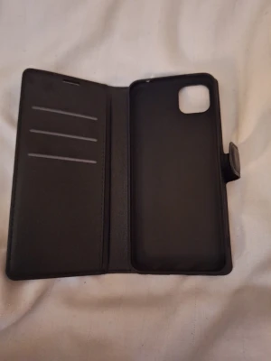 Mobilskal samsung galaxy a22 5g - Sprillans nytt mobilskal som är helt oanvändt. Svart färg och i läder. Passsar perfekt på mobilen och rymmer upp till 8 kort i facket.