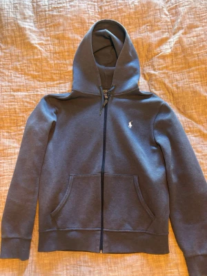 Polo Ralph Lauren zip  - Snygg mörkblå hoodie från Polo Ralph Lauren med dragkedja, huva och fickor framtill. Klassisk logga broderad på bröstet. Tillverkad i mjukt bomullsmaterial som känns skönt mot huden. Kvitto finns.