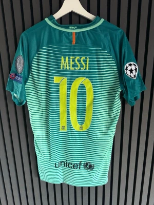 Barcelona Messi matchtröja turkos - Säljer en turkos Barcelona matchtröja från Nike med Messi och nummer 10 på ryggen. Tröjan har Champions League-patchar på ärmarna, klubbmärke och Qatar Airways-logga framtill samt Unicef-logga bak. Tillverkad i lätt och ventilerande material, perfekt för fotboll.