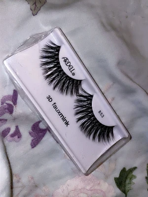 Ardell 3D Faux Mink Fransar 853 - Säljer ett par Ardell 3D faux mink lösögonfransar i modell 853. Fransarna är svarta, fluffiga och har en voluminös 3D-effekt för en intensiv look. Tillverkade av syntetiskt material som efterliknar minkhår. Perfekta för dig som vill ha extra fylliga fransar.