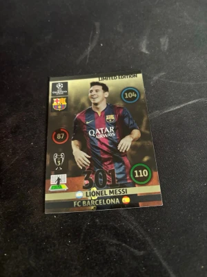 Limited Edition Messi samlarkort - Säljer ett Limited Edition samlarkort från Panini med Lionel Messi i FC Barcelona. Kortet har guldiga detaljer, klubbmärke, Champions League-logga och statistik. Framsidan visar Messi i Barcelonas vinröda och blå matchtröja. Baksidan har en siluett och onlinekod.