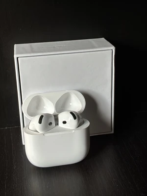 Apple AirPods 4 trådlösa hörlurar - Säljer ett par vita Apple AirPods Pro med laddningsetui. De är trådlösa in-ear-hörlurar med stilren design och smidigt fodral. Perfekta för musik, samtal och träning. Levereras med originalförpackning. Har tappat dem en gång så det är något i dem som låter från frodaalet därav ptis