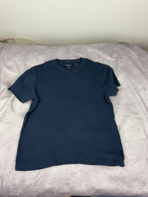 Mörkblå t-shirt från Bondelid - En stilren mörkblå t-shirt från Bondelid med klassisk rund hals och korta ärmar. Tillverkad i mjuk bomull som känns skön mot huden. Perfekt till jeans eller shorts för en enkel och clean look.