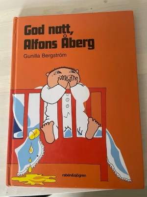 God natt, Alfons Åberg bok - Barnbok med hårda pärmar, orange omslag och illustration av Alfons Åberg i sin säng. Skriven av Gunilla Bergström. Perfekt för högläsning och kvällsrutiner. Klassisk svensk barnlitteratur med charmiga bilder och enkel text.