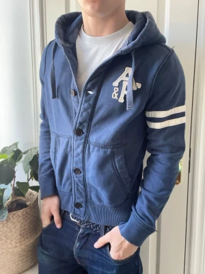 Abercrombie and fitch cardigan  - Abercrombie and fitch cardigan, Inga defekter men dens design är vintage / lite sliten! Modellen i bilderna är 180 cm 75 kg och bär Storlek S lite liten på modellen , Kom med frågor! 🌟 (Kan gå ned i pris vid köp av paket 😉) 