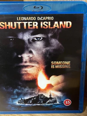 Shutter Island Blu-ray - Shutter Island på Blu-ray med Leonardo DiCaprio i huvudrollen. Omslaget är blått och fodralet är gjort av plast. Filmen är en psykologisk thriller regisserad av Martin Scorsese. Text på svenska, danska, norska och finska. Åldersgräns 15 år.
