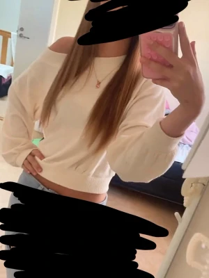 Off shoulder cremevit stickad tröja - Trendig cremevit stickad tröja med off shoulder-design och avslappnad passform. Tröjan har långa ärmar och bred ribbad mudd vid ärmslut och nederkant. Perfekt för en chill och snygg look.