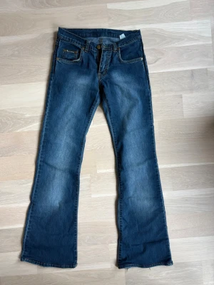 Vintage blå bootcut jeans - Vintage jeans med bootcut passform! På jeansen finns märket Dolce & Gabbana men de är ej akta, däremot är de fortfarande väldigt snygga! Det står ingen storlek i byxorna men passar som en S! Jag är öppen att mäta jeansen så det är bara att meddela mig.
