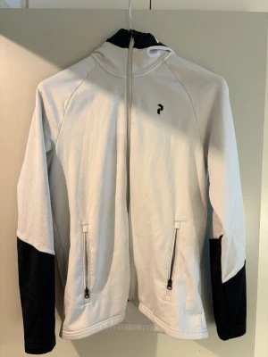 Vit tröja med huva från Peak performance  - Snygg vit tröja från Peak performance rekommenderar starkt om du är väldigt aktiv samt söker för en snygg stil som passar till allt. Väldigt bekväm och inga bekymmer med tröjan Nypris: 1500
