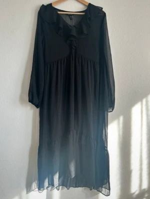 Svart långklänning från New Look storlek L - Helt ny lång svart klänning från New Look i storlek XL men sitter mer som en L. Den är i ett genomskinligt tyg och kommer med en svart slip on underklänning. Nypris 400 kr. Sitter fortfarande i sin originalförpackning. Frakt ingår ej. 