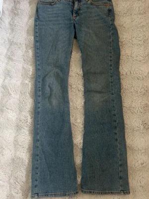 Blå bootcut jeans med fickor - Ett par klassiska blå bootcut jeans. Jeansen har en rak passform upptill och lätt utsvängda ben. Byxorna är från junkyard och är endast använda fåtal gånger.