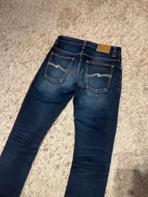 Nudie jeans modell grim tim med wash unik fade slim w28 L dry denim - Nudie jeans i modell grim tim som sitter slim. Har en riktigt snygg och unik fade. Mycket bra skick, utan några märkvärdiga defekter. Storlek w28 L 32. Postas samma dag som köp eller dagen därpå🙌💯