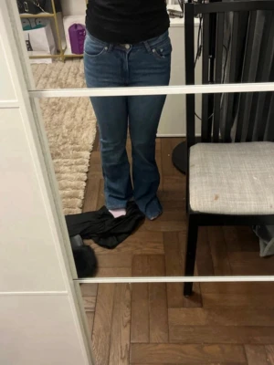 Blå bootcut jeans från Levi's - Säljer ett par klassiska blå bootcut jeans från Levi's med fem fickor och snygga sömmar. Jeansen har normalhög midja och är tillverkade i stretchigt denim för en bekväm passform. Perfekta för dig som gillar en tidlös och avslappnad stil.