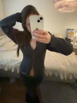 Grå tröja från Gina Tricot - Säljer en grå tröja med knappar längs framsidan från Gina Tricot med v-ringning. Koftan har långa ärmar och är gjord i ett mjukt, tunt stickat material som sitter snyggt och figurnära. 