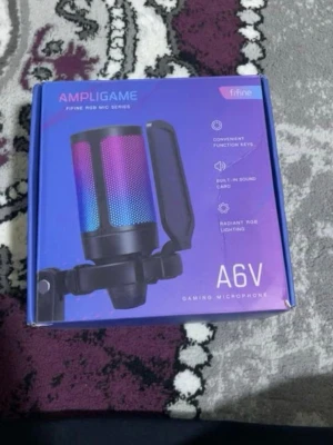 Fifine AmpliGame A6V RGB mikrofon - Säljer en Fifine AmpliGame A6V gamingmikrofon med RGB-belysning. Mikrofonen har USB-anslutning, inbyggt ljudkort, popfilter och touch-funktion för mute. Perfekt för streaming, gaming eller podd. Svart design med färgglada ljuseffekter.