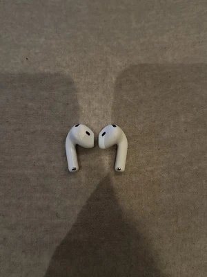 AirPods 4 (endast hörlurarna) - Säljer AirPods 4 (endast hörlurarna, ingen laddningsbox medföljer) då jag tappat bort boxen.  Senast jag använde dem fungerade båda som de ska. Säljs därför endast som hörlurarna utan box/case. 