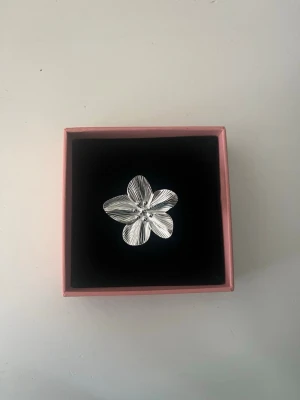 Silverfärgad blomring - Säljer en söt Stockholmstil ring med en silvrig blomma på. Ringen är justerbar! Jag säljer flera snygga, liknande ringar, blir billigare vid köp av flera!❤️