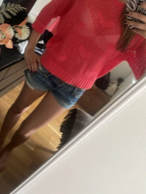 Rosa meshtröja med hjärtmönster - Säljer en rosa, genombruten meshtröja med söta hjärtmönster. Tröjan har trekvartsärmar, bred halsringning och ribbade muddar. Perfekt för lager på lager och ger en cool, avslappnad vibe till din outfit.