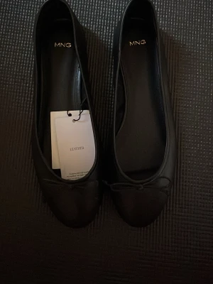 Svarta ballerinaskor från Mango  - Svarta ballerinaskor i läder. Helt oanvända med prislappen kvar! Super fina.