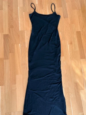 Svart långklänning med tunna band - Svart långklänning med tunna band, använt någon enstaka gång. Går enda ner till fötterna på mig som är ca 168 cm, om jag minns rätt är den nästan lite för lång  