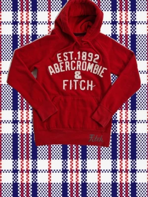 Abercrombie & Fitch hoodie röd - En abercrombie & fitch hoodie med cool design i bra skick. Storlek XS. Mått: Armlängd: 64cm armhåla-armhåla (bredd): 41cm Armbredd: 14 cm axel-midjeslut (längd) : 60cm
