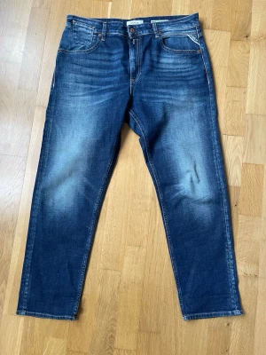 Mörkblå slim fit jeans - Snygga mörkblå jeans med slitningar och tvättade detaljer. Klassisk femficksmodell med smal passform och normal midja. Jeansen har dragkedjegylf och är tillverkade i stretchigt denimtyg för extra komfort.