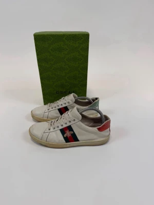 Gucci Ace Skor - Storlek 41 (7). Skick 4/5. Nypris 10.000, vårat pris 2199. Riktigt snygga o stilrena dojjer till sommaren! Originalbox ingår. Hör av dig vid minsta lilla fundering.