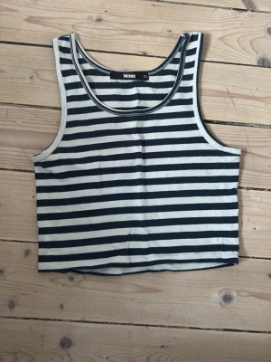 Randig croppad linnetopp från Bik Bok - Säljer en croppad linnetopp från Bik Bok i marinblå och vitt med klassiskt randigt mönster. 